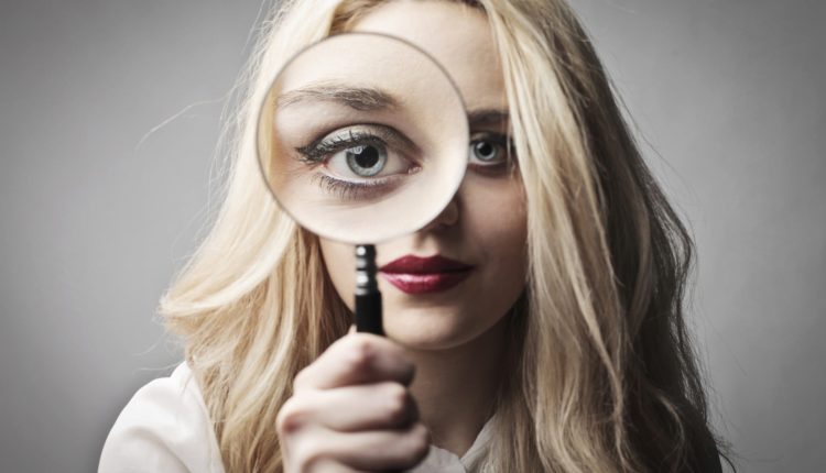 Young woman holding a magnifying glass